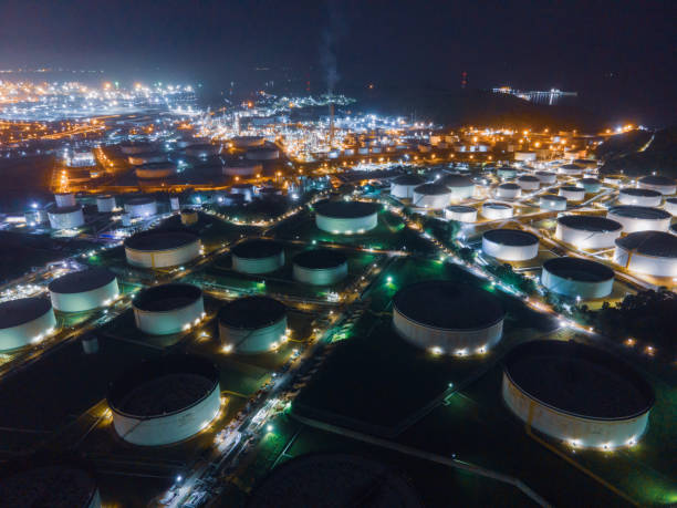 luftbild drohnenaufnahme von lagertank und ölraffinerie in industrieanlagen in der nacht. brennstoff- und stromerzeugung, petrochemische fabrikindustrie oder umweltverschmutzungskonzept - petrochemical plant stock-fotos und bilder