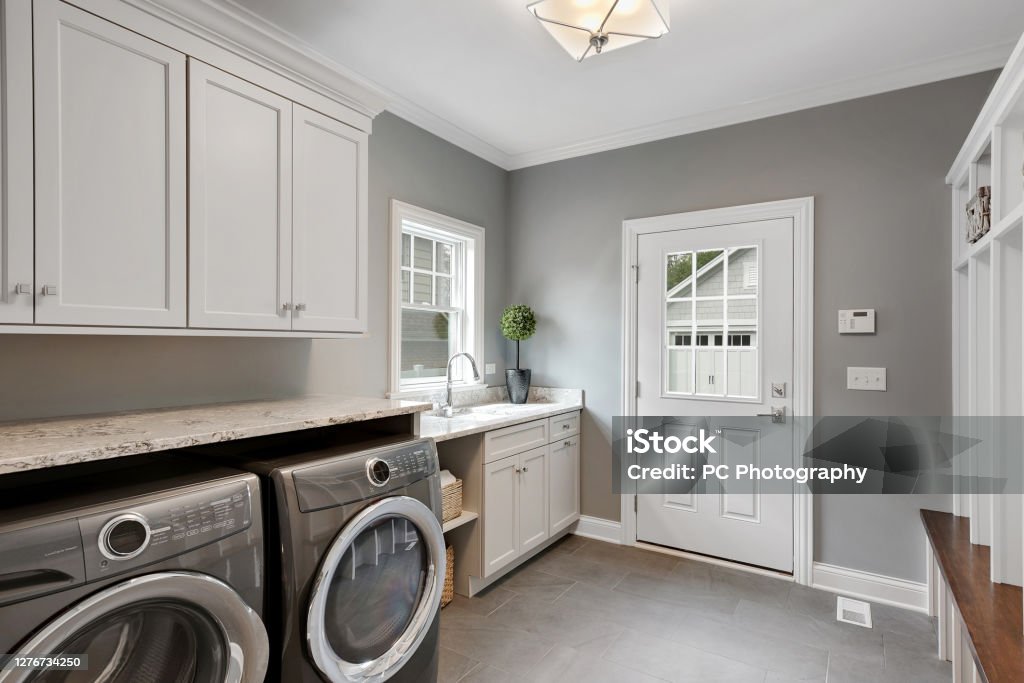 Perfect laundry room and mud room combination Large front loading washer and dryer in newly built home Utility Room Stock Photo