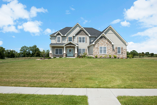 Sidewalk crosses path of large spacious front lawn of new home