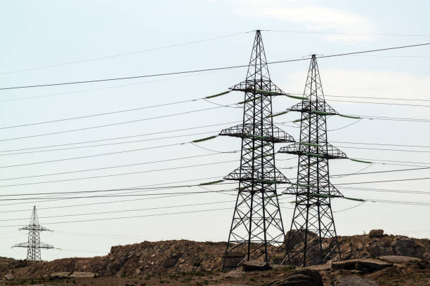 istock High voltage lines and power pylons in field 1276739553