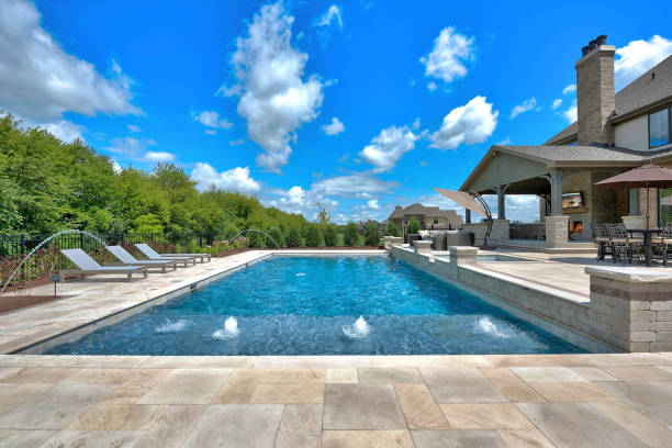 grande piscine avec chaises longues et dispositifs de jet d’eau - rebord de piscine photos et images de collection