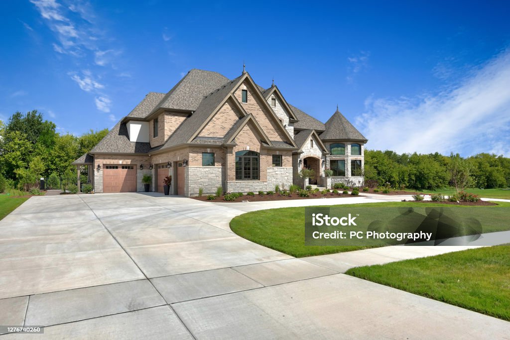 Large home with driveway leading to three car garage Exquisite craftsmanship on newly built Tour home in Illinois House Stock Photo
