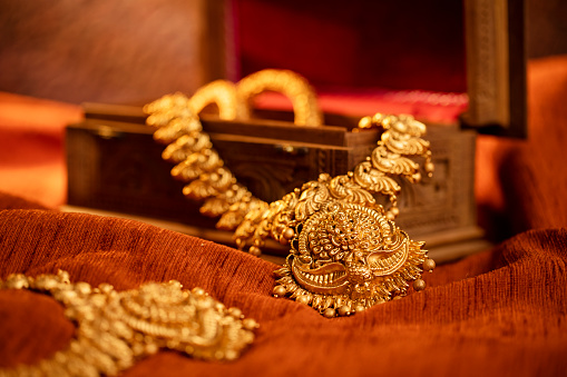 A golden scrap of old gold jewelry on black background