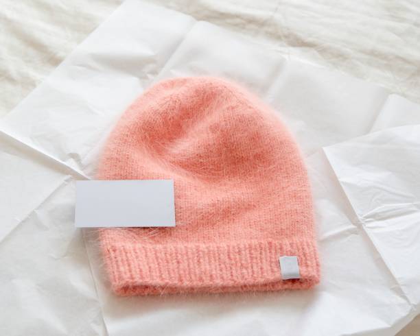 knitted peach hat on white craft paper