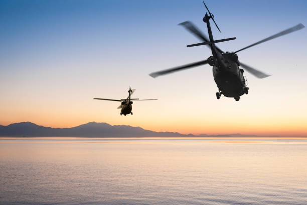 일몰에 바다 위에 두 비행 육군 헬리콥터 - us military helicopter sunset armed forces 뉴스 사진 이미지