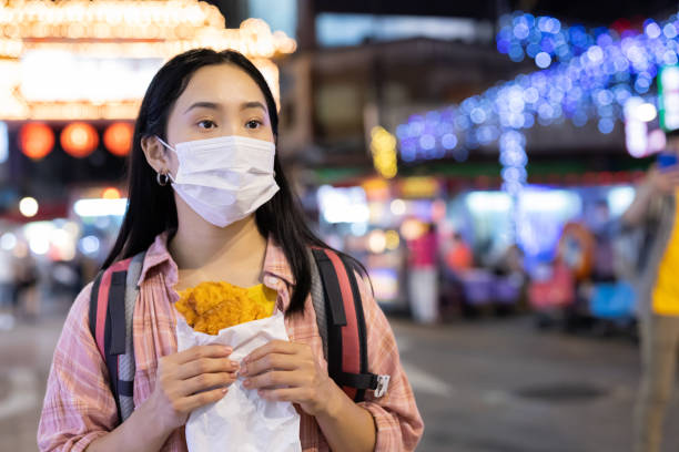 istock female backpackers in night market 1276751573