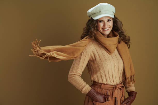 istock smiling modern woman in sweater isolated on bronze background 1276751671