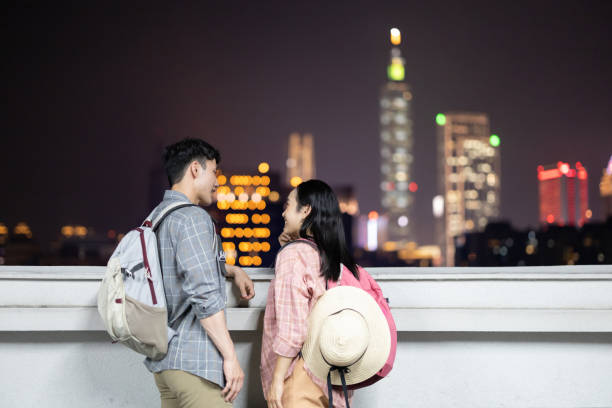 istock couple backpackers with night city 1276753011