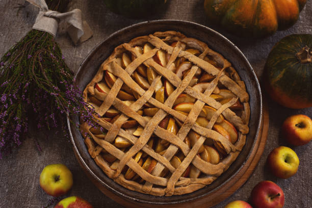 istock Preparation, Thanksgiving Day celebration. View from above. Baked apple pie in a baking sheet. Close-up. In the background are pumpkins. Making a traditional apple pie. 1276753321