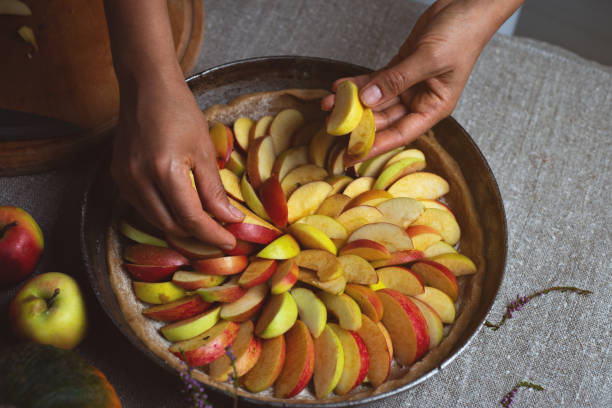 istock Preparation, Thanksgiving Day celebration. The chef finishes adding apples to the pie. Making a traditional apple pie. 1276753964