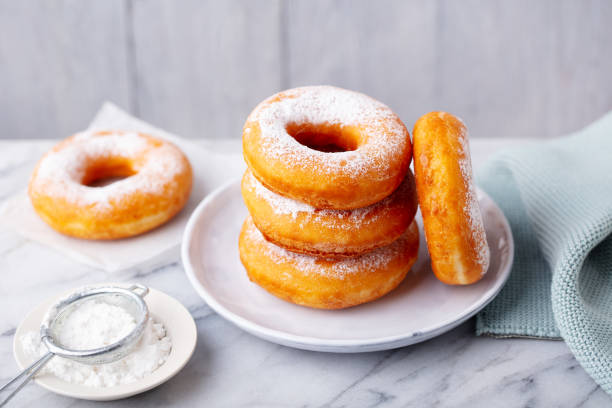 istock Donuts with sugar powder on a plate. Grey background. Close up. 1276754622