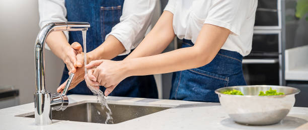 gros plan homme et femme se lavant les mains frottant avec du savon pour la prévention du virus corona dans la cuisine sous le robinet d’évier d’eau pour la cuisson, l’hygiène pour arrêter la propagation de la bannière concept de coronavirus - rubbing human hand togetherness women photos et images de collection