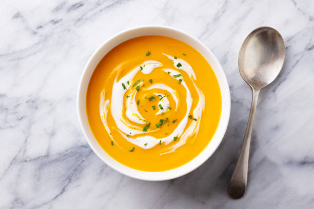 istock Pumpkin soup with cream. Marble background. Close up. Top view. 1276756625