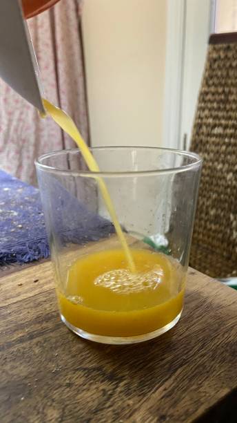 istock Orange juice on wooden table 1276757022