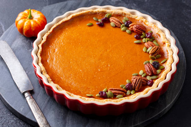 istock Pumpkin pie, tart in baking dish. Black background. Close up. 1276757139