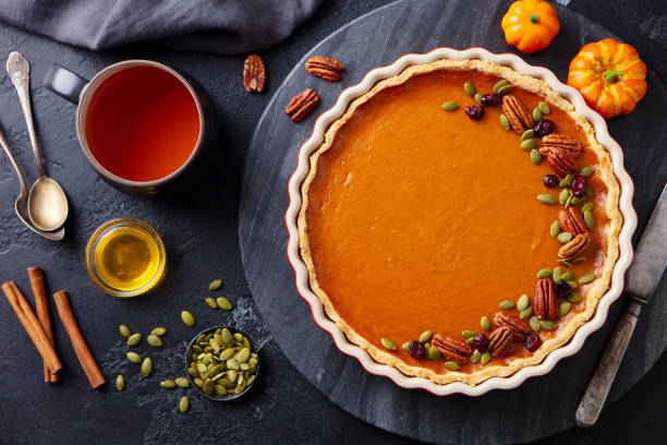 istock Pumpkin pie on marble board with cup of tea. Grey background. Close up. Top view. 1276757330