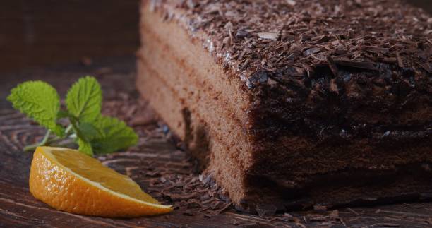 istock Chocolate cake decorated with fresh orange and mint. Extreme close-up 1276757414
