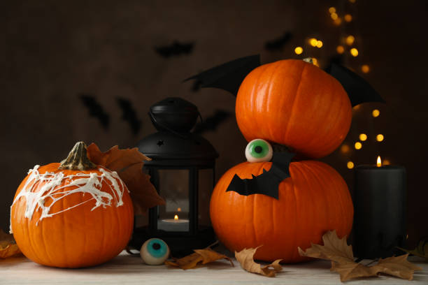 istock Halloween concept with pumpkins on brown background with blurred lights 1276762484