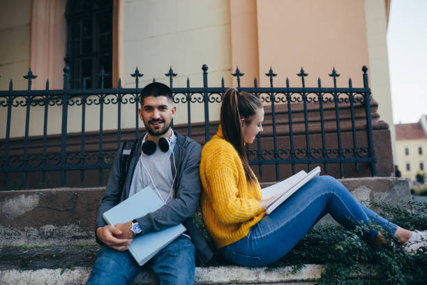 istock students outdoor hanging and reading books 1276762631