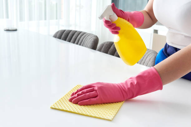 istock Cleaning home table sanitizing kitchen table surface with disinfectant spray bottle washing surfaces with towel and gloves. COVID-19 prevention sanitizing inside 1276763568