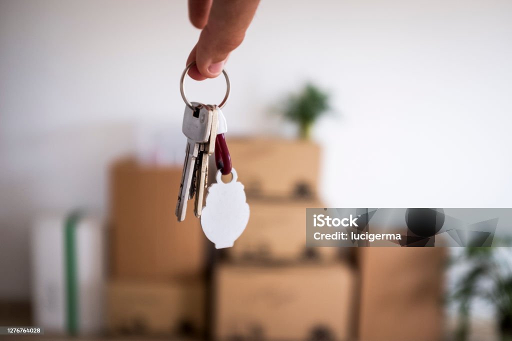 Primer plano de las llaves del nuevo apartamento vacío con cajas móviles en el suelo - Foto de stock de Mudanza libre de derechos