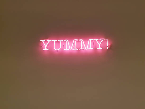 istock a pink neon sign with the word yummy! 1276765780