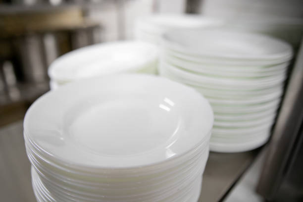 istock Stacks of many white plates on a wire rack shelf in a commercial kitchen 1276767012