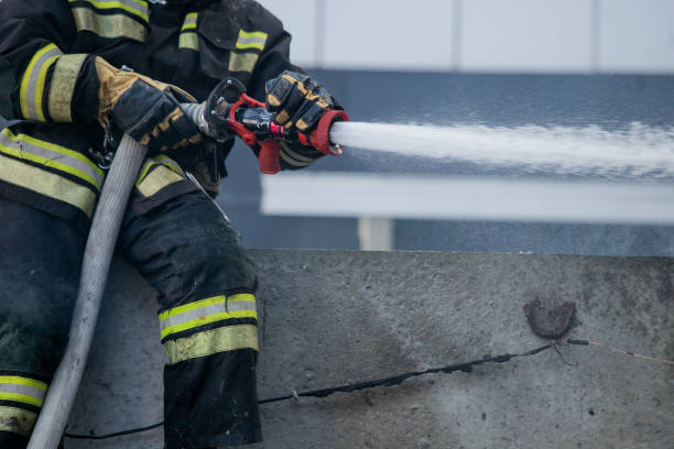 istock Firemen using extinguisher and water from hose for fire fighting in firefight training. Firefighter wearing fire suit for protect and safety under danger case.This team is under civil service system. 1276767066