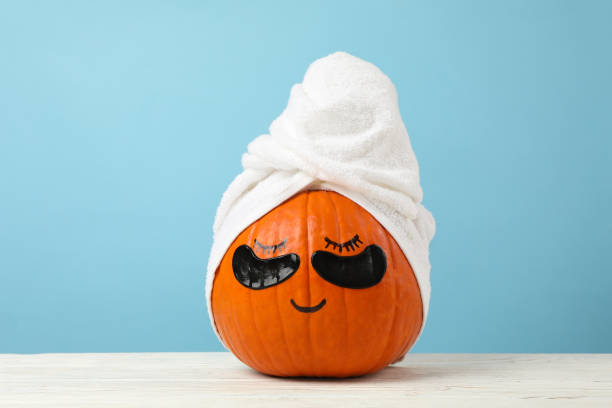 istock Pumpkin with towel and under eye patches against blue background 1276767071