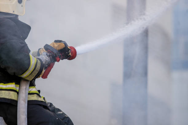 istock Firemen using extinguisher and water from hose for fire fighting in firefight training. Firefighter wearing fire suit for protect and safety under danger case.This team is under civil service system. 1276767199
