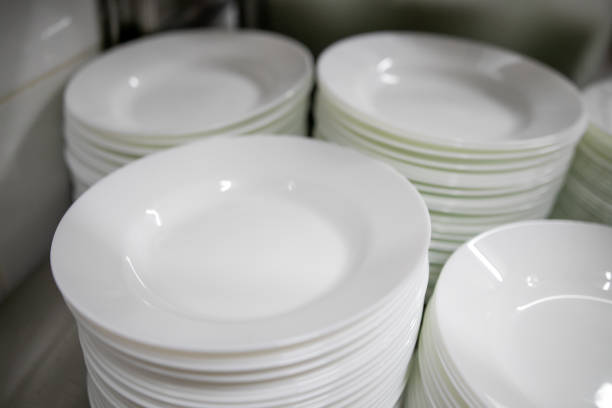 istock Stacks of many white plates on a wire rack shelf in a commercial kitchen 1276767255