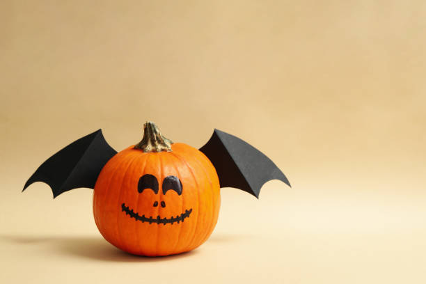 istock Pumpkins with smile and wings on beige background 1276767584