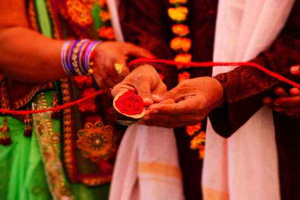 Indian Couple Hold Red Flower on Hand During Holly Pooja stock photo