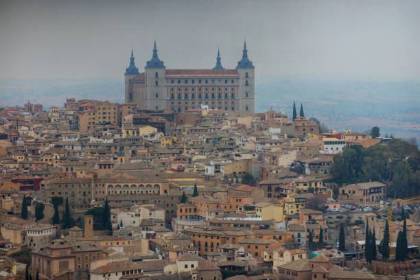 A photo of Toledo in January on a foggy morning. You can see the city and the Alcazar in the background.