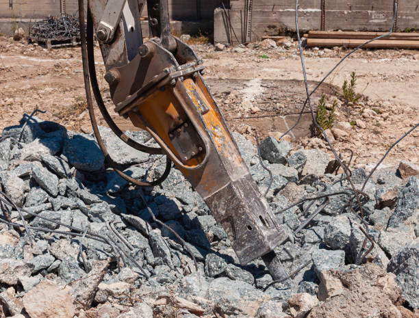 istock Concrete rubble debris on construction site, Crushed concrete slabs and steel bars,Demolition excavator with hydraulic jack hammer is destroying a Reinforced Concrete with recycle steel bar. 1276771275