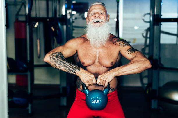 istock Hipster senior man training inside gym - Mature tattooed person having fun doing workout exercises in sport fitness club - Active joyful elderly lifestyle and fit concept - Focus on hands 1276775248