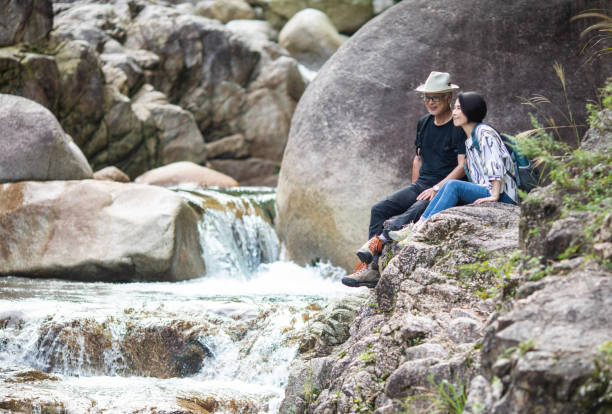 istock Senior couple hiking and enjoying a waterfall 1276775372