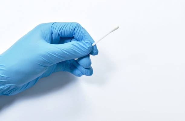 istock hand wearing blue glove holding cotton bud for testing coronavirus or COVID-19 on white background 1276775425