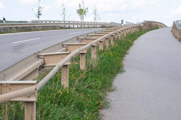 a crash barrier dividing the road for cars and a pathway for pedestrians and bicyclists