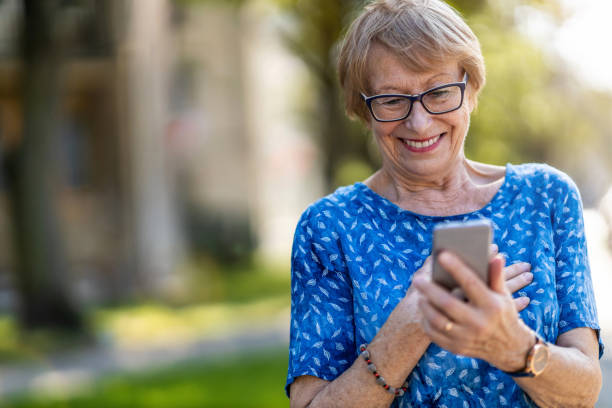 istock Happy senior woman using mobile phone outdoors 1276776729