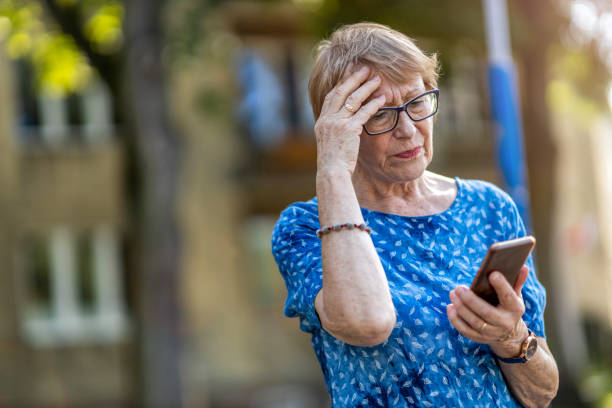 istock Stressed senior woman using mobile phone outdoors 1276776769
