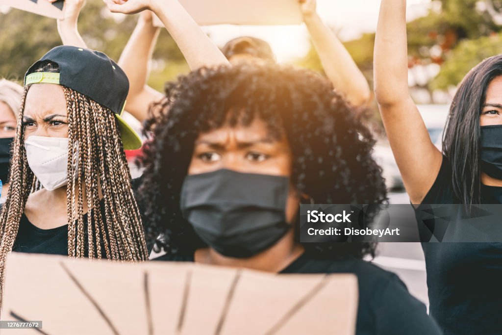 Multiracial people protest on the street for equal rights - Focus on left girl face Racism Stock Photo
