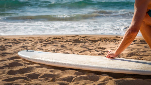 istock Man waxing a surfboard on the beach 1276778721