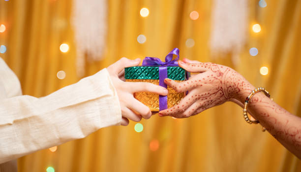 Close up of Brother Hands Giving gift to sister during during raksha Bandhan, Bhai Dooj or Bhaubeej Indian religious festival Close up of Brother Hands Giving gift to sister during during raksha Bandhan, Bhai Dooj or Bhaubeej Indian religious festival . rakhi stock pictures, royalty-free photos & images