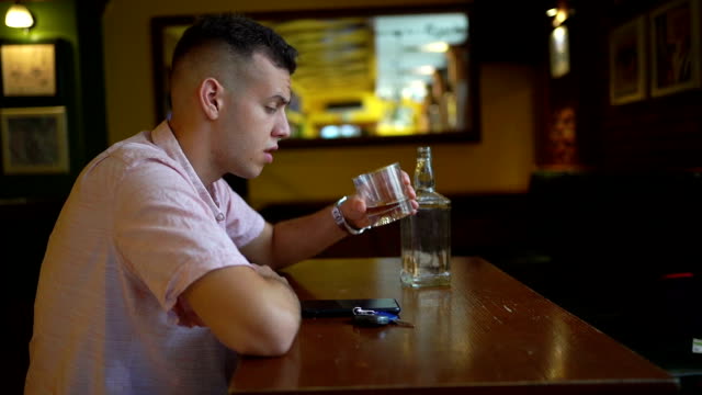 Upset man sitting with glass drinking whiskey