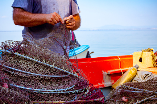 Fisherman is pile up fishing net and prepare for his next angling.