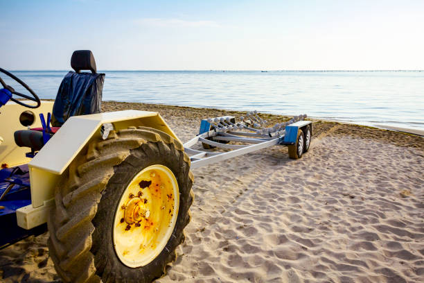 трактор с прицепом для транспортных катеров на песчаном пляже - vehicle trailer nautical vessel towing yacht стоковые фото и изображения