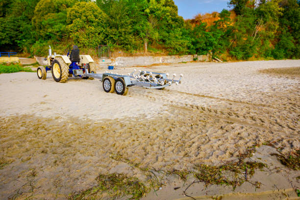 모래 해변에서 수송 보트에 대한 트레일러와 트랙터 - vehicle trailer nautical vessel towing yacht 뉴스 사진 이미지