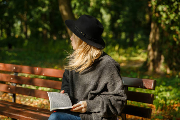istock girl in the park with a book 1276800492