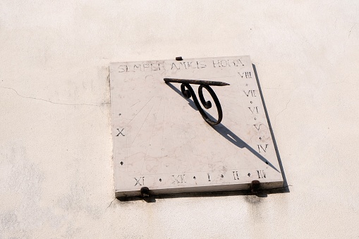 Solar clock in close-up on a white wall